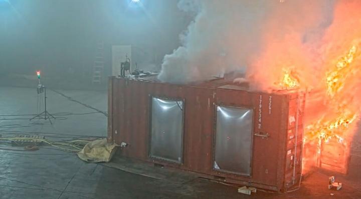 small building on fire inside of a large lab