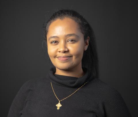 woman wearing dark shirt and gold necklace