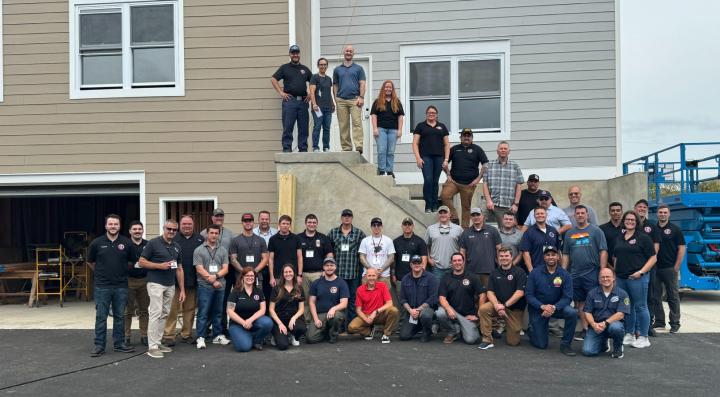 Group photo of the technical panel members and FSRI staff standing in front of the townhome and rowhome built for this project in Sharon Hill, PA