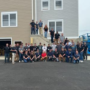 Group photo of the technical panel members and FSRI staff standing in front of the townhouse and rowhome built for this project in Sharon Hill, PA