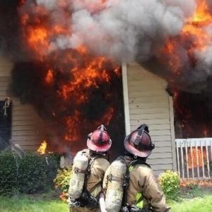 firefighters infront of a burning structure 